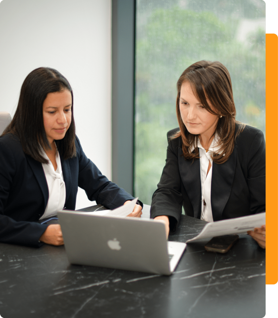 3 Two lawyers reviewing documents while sitting at a laptop